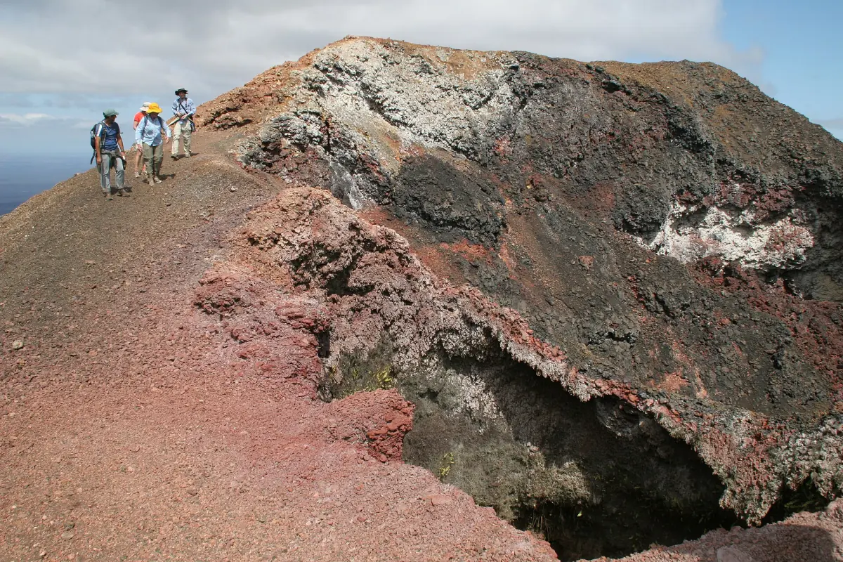 Hikers on red lava at Sierra Negra